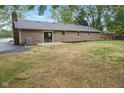 Brick home exterior featuring a concrete patio and well-maintained landscaping at 4645 Quail Run Dr, New Palestine, IN 46163