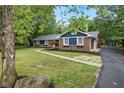 Charming brick home with blue accents, walkway, mature trees, and well-maintained landscaping at 4645 Quail Run Dr, New Palestine, IN 46163