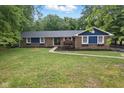 Beautiful brick home with blue accents, mature trees, and walkway leading to front door at 4645 Quail Run Dr, New Palestine, IN 46163