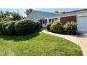 A well-manicured front yard featuring lush green grass, shrubs, and a walkway to the front door at 5491 Vin Rose Ln, Lawrence, IN 46226