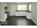 The bright kitchen features white cabinets, dark countertops, and stainless steel appliances at 620 S 2Nd St, Noblesville, IN 46060