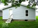 View of back of house and walkout basement, white siding, window, door, and small set of steps at 620 S 2Nd St, Noblesville, IN 46060
