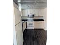 Traditional-style kitchen with white appliances, dark countertops, and vinyl flooring at 6322 Commons Dr, Indianapolis, IN 46254