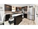 Modern kitchen featuring dark cabinetry, stainless steel appliances, and a center island with a white countertop at 6883 Honeysuckle Way, Pendleton, IN 46064