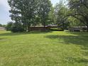 Large backyard showcasing a well-maintained lawn and mature trees, perfect for outdoor activities at 7088 Sandalwood Dr, Indianapolis, IN 46217
