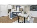 A view of a kitchen and dining area with stainless steel appliances, wooden floors, and modern decor at 7177 Firestone Rd, Whitestown, IN 46052