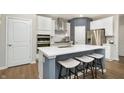 Island seating in a kitchen with white cabinets, stainless steel appliances, and a modern design at 7177 Firestone Rd, Whitestown, IN 46052
