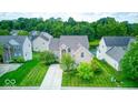 Charming two-story home with mature trees in front and a glimpse of a pond in the back at 7212 Maple Bluff Pl, Indianapolis, IN 46236