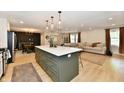 Open concept kitchen with a large island, modern lighting, and views to the dining and living area at 7242 Highburry Dr, Indianapolis, IN 46256