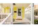 Close-up of the front porch with a swing, white railing, and entrance to a bright yellow house at 743 Sanders St, Indianapolis, IN 46203