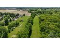 Wooded and partially cleared property with homes in the distance showcasing potential for development or a private estate at 7811 N County Road 500 E, Pittsboro, IN 46167