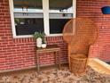 Charming wicker chair sits outside, enhancing curb appeal with a vintage touch and fresh flowers at 8990 N 850 W, Fairland, IN 46126