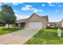 Charming brick home featuring a well-manicured lawn, two-car garage, and inviting front porch at 1056 Hilltop Commons Blvd, Whiteland, IN 46184