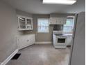 Well-lit kitchen featuring white appliances and ample cabinet space at 114 S Green St, Brownsburg, IN 46112