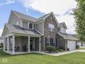 Beautiful exterior view of a brick home showcasing a welcoming front porch and well-maintained landscaping at 1215 W Curry Rd, Greenwood, IN 46143