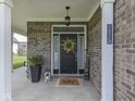 Inviting front porch with decorative plants, wreath, and a 'welcome' sign at 1215 W Curry Rd, Greenwood, IN 46143