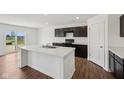 Bright kitchen featuring a center island, stainless steel sink and laminate wood floor at 1304 Vera Blvd, Danville, IN 46122