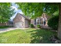Charming single-story brick home featuring an attached two-car garage and a well-kept lawn at 13910 Brightwater Dr, Fishers, IN 46038
