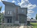 Contemporary two-story home boasts neutral siding, a balcony, unique wood accents, and meticulous landscaping at 1622 Cornell Ave, Indianapolis, IN 46202