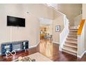 Cozy living area showcasing hardwood floors, adjacent kitchen view, and staircase at 2230 N Pennsylvania N St # 7, Indianapolis, IN 46205