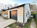 View of the home with a detached garage and a small lawn area at 4108 Patricia St, Indianapolis, IN 46222