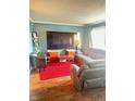 Cozy living room featuring a large TV, plush seating, and a vibrant red rug at 4108 Patricia St, Indianapolis, IN 46222