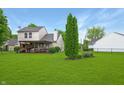 Spacious backyard with a lush green lawn, mature trees, and a covered patio perfect for outdoor enjoyment at 4442 Victory Cir, Indianapolis, IN 46203