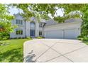 Gorgeous two-story home featuring a blue front door and a spacious driveway leading to the garage at 4763 Woods Edge Dr, Zionsville, IN 46077