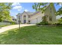 Beautiful white brick house with an expansive front lawn, landscaped with trees and manicured shrubs at 4763 Woods Edge Dr, Zionsville, IN 46077