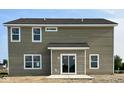 Rear view of a house with siding, sliding glass door leading to a patio, and several windows at 5002 Amber Wood Dr, Lawrence, IN 46235