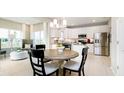 Bright eat-in kitchen featuring white cabinets, stainless steel appliances, and a modern chandelier at 5002 Amber Wood Dr, Lawrence, IN 46235