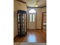 Spacious foyer with hardwood floors, a glass curio cabinet, and a decorative front door at 5148 Constitution Ct, Columbus, IN 47203