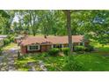 A charming brick ranch home with a well-maintained lawn and mature trees under a blue sky at 5240 Southdale Dr, Indianapolis, IN 46217
