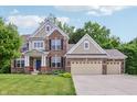 Charming two-story brick home boasting a three-car garage, well-manicured lawn and inviting curb appeal at 5441 Ellsworth Dr, Plainfield, IN 46168