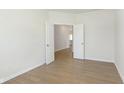 Well-lit bedroom with modern wood-look flooring, white trim, and a doorway at 7151 Stetson Dr, Whitestown, IN 46052