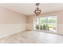 Bright dining room with tile floors, modern lighting, and large windows offering scenic views at 7405 N Janna Dr, Muncie, IN 47303