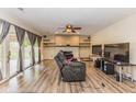 Spacious living room with wood floors, fireplace, sliding glass doors and a ceiling fan at 7405 N Janna Dr, Muncie, IN 47303