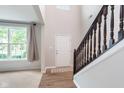 Inviting foyer with hardwood flooring, a staircase featuring dark wood banisters, and plenty of natural light at 8556 N Deer Hill Dr, McCordsville, IN 46055