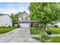 Inviting two-story home showcasing a manicured lawn, charming front garden, and a convenient two-car garage at 9605 Treyburn Green Way, Indianapolis, IN 46239
