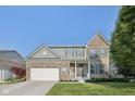 Two-story brick and siding home features a manicured lawn, shutters, and a two-car garage at 9840 N Anchor Bnd, McCordsville, IN 46055