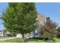 A two-story brick home with shutters, a green lawn, and mature landscaping at 9840 N Anchor Bnd, McCordsville, IN 46055