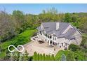 Aerial view of backyard of large home with manicured landscaping, covered patios, and mature trees at 10707 Club Chase, Fishers, IN 46037