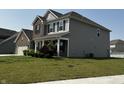 A lovely two-story home with a welcoming front porch, complemented by lush green landscaping at 1218 Bedford Dr, Avon, IN 46123