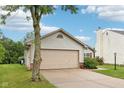Single-story home with two car garage and a mature tree in front at 12207 Blue Sky Dr, Fishers, IN 46037