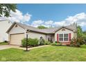 Single-story home with red shutters, landscaped front yard, and two car garage at 12207 Blue Sky Dr, Fishers, IN 46037
