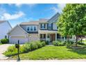 Traditional two-story home featuring a two-car garage, well-kept lawn, and a welcoming porch at 16138 Palmyra Green, Westfield, IN 46074