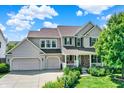 Charming two-story home with a well-maintained lawn, two-car garage, and inviting front porch at 16138 Palmyra Green, Westfield, IN 46074