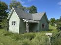 Charming home featuring weathered green siding, a gray roof, and a yard that needs tending at 1739 E 18Th St, Anderson, IN 46016