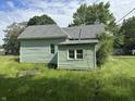 Rear view of home with green siding, a visible roof vent, and lush green yard at 1739 E 18Th St, Anderson, IN 46016
