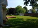 Expansive backyard with a wooden deck, lush greenery, and a storage shed at 18851 Wimbley Way, Noblesville, IN 46060